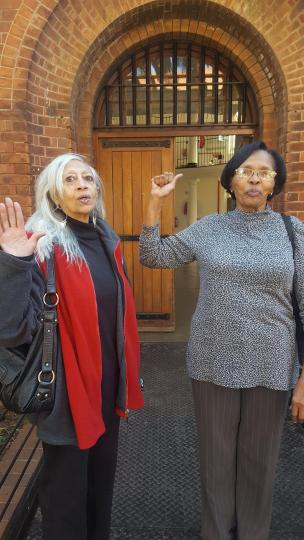 Juby Mayet and Cecilie Palmer standing in front of Constitution Hill Women's Prison